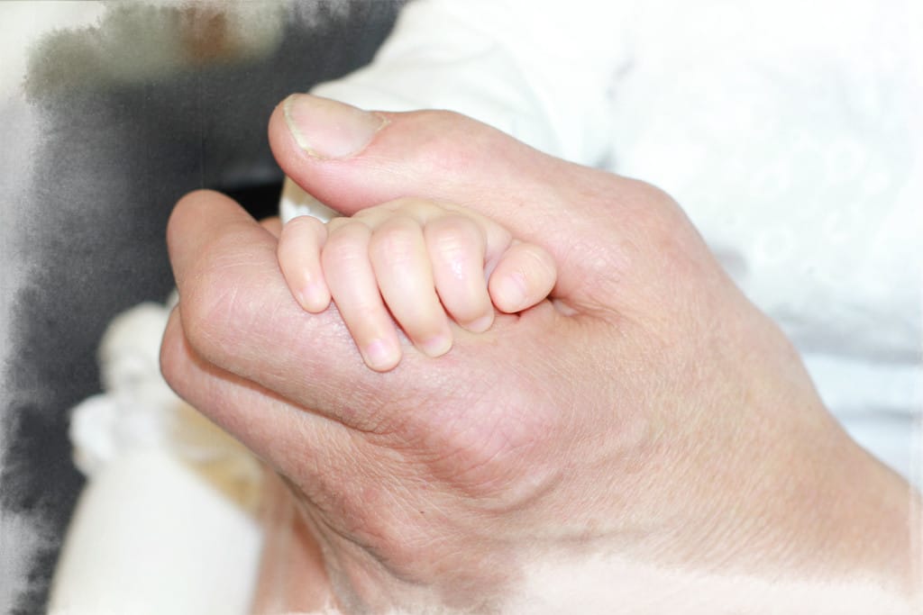 An old hand holding a small one