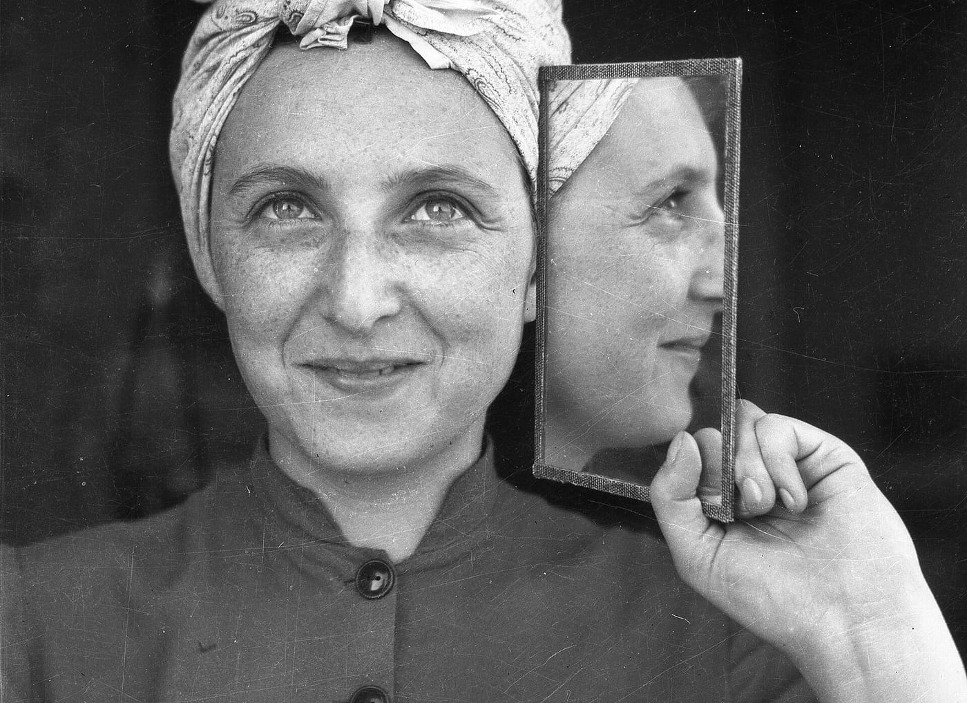 A woman holding a mirror to her face